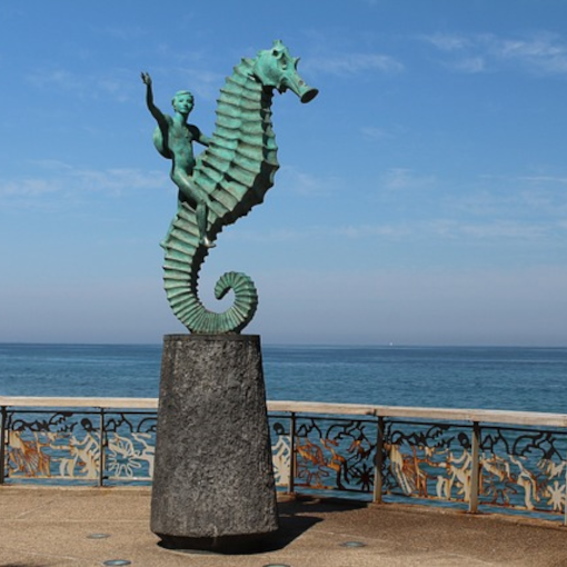 Statue overlooking the ocean of a boy riding a seahorse
